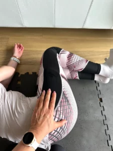 Exercice de pilates au sol pour travailler la mobilité de la hanche et le renforcement doux.