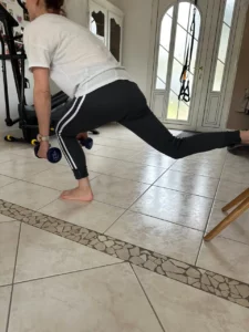 Exercice de fente arrière avec haltère pour renforcer les jambes, améliorer l’équilibre et la posture.